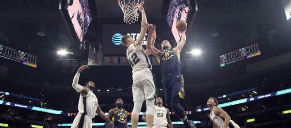 Форвард Индиана Пэйсерз Домантас Сабонис (11-й номер) забивает мяч через легкого форварда Сан-Антонио Сперс Дависа Бертанса (42-й номер) - Sputnik Латвия