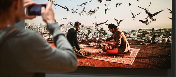 Посетитель на открытии выставки победителей IV международного конкурса фотожурналистики имени Андрея Стенина в Москве - Sputnik Латвия